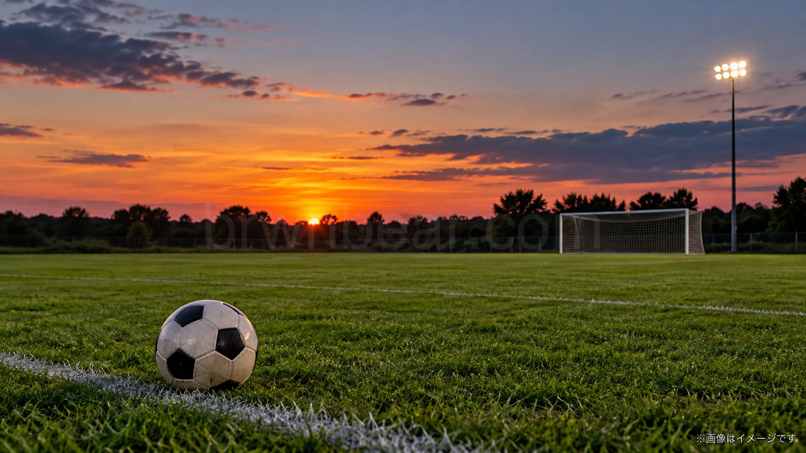夕暮れの無人のサッカーグラウンドとボールのイメージ