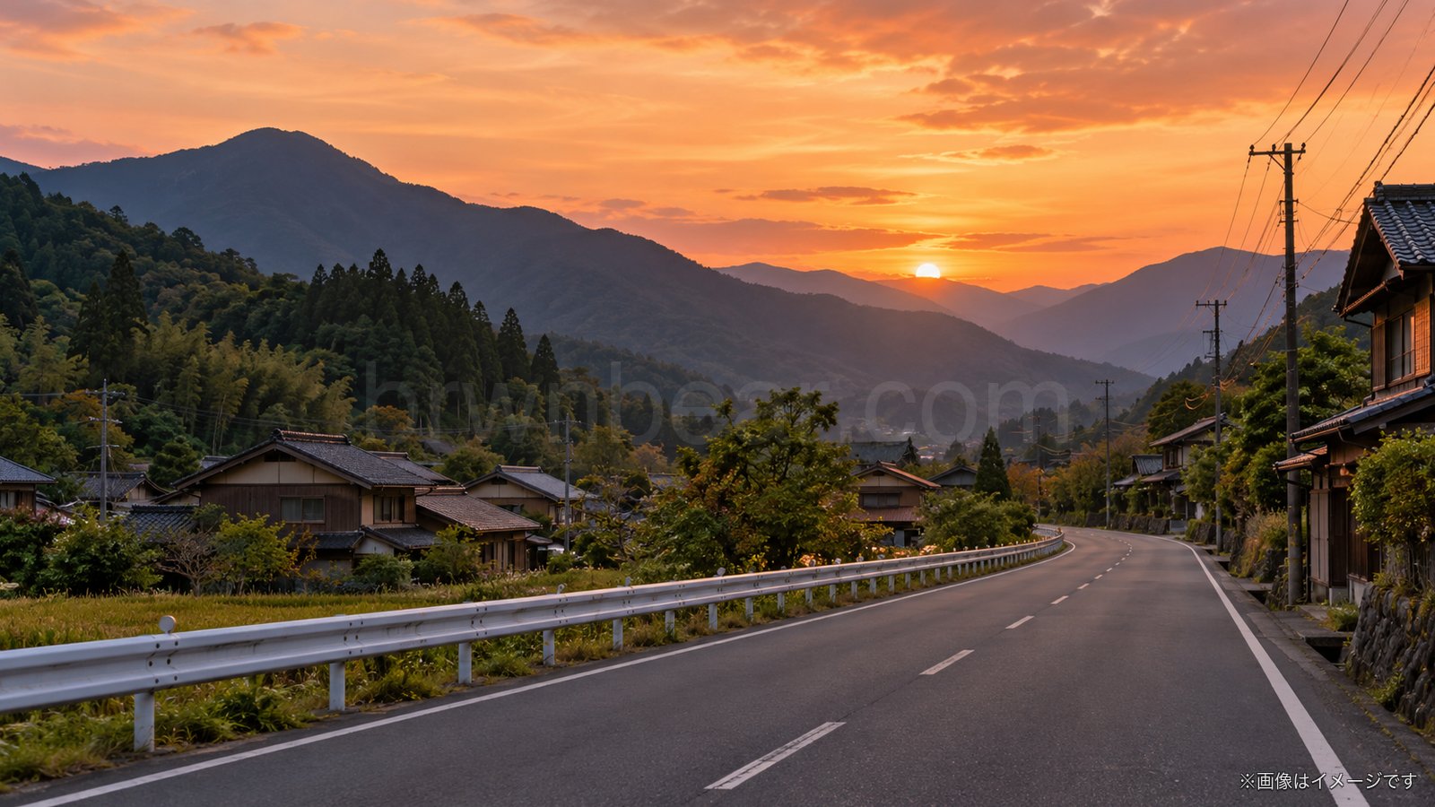 夕暮れの山あいの集落と道路のイメージ